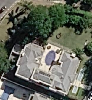 Vista aérea da implantação: a residência e o terreno arborizado ao redor